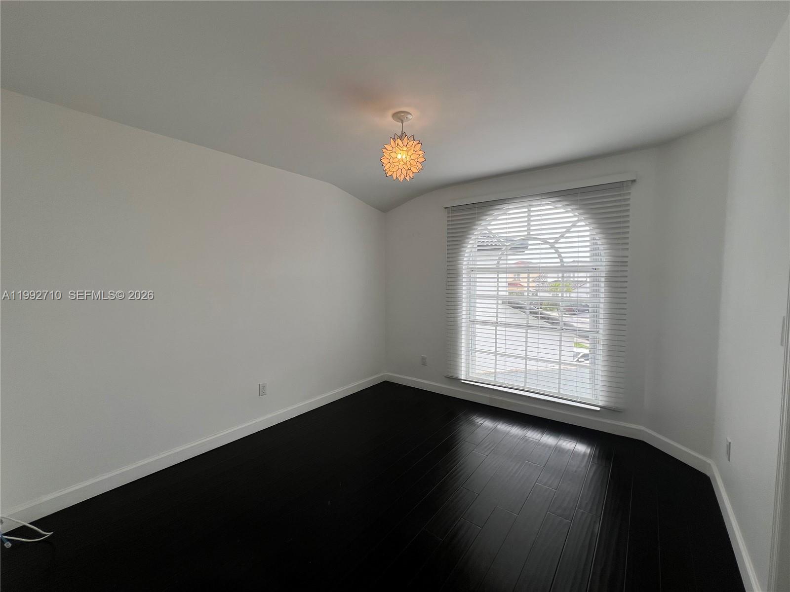 15511 Southwest 59th Street Miami, FL 33193 - Photo 27 of 34 an empty room with wooden floor and windows