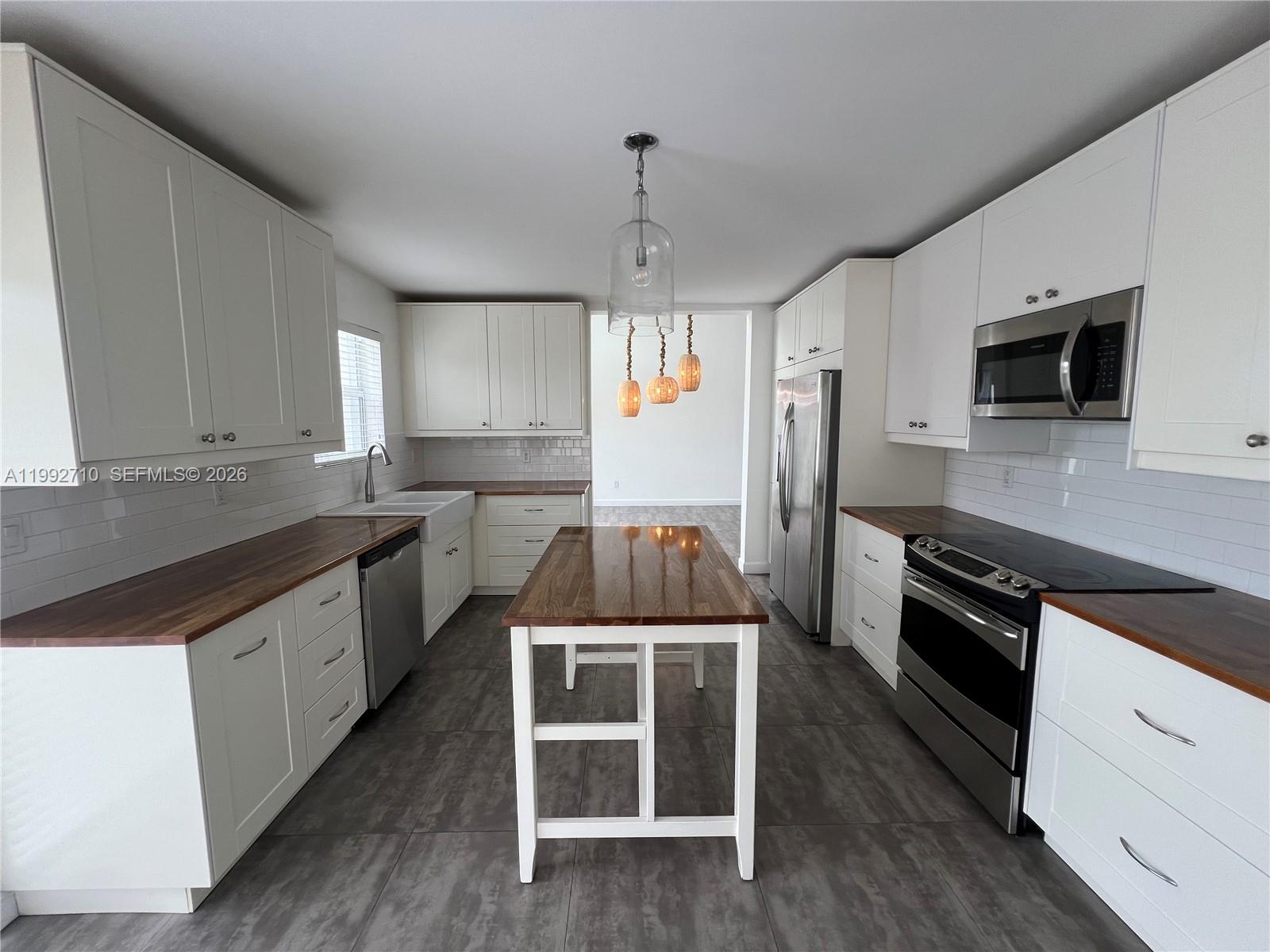 15511 Southwest 59th Street Miami, FL 33193 - Photo 3 of 34 a kitchen with a sink stove and refrigerator