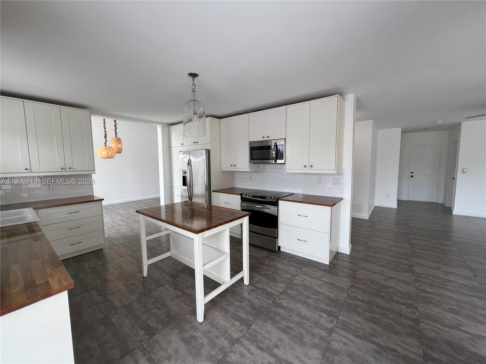 15511 Southwest 59th Street Miami, FL 33193 - Photo 8 of 34 a kitchen with white cabinets and stainless steel appliances