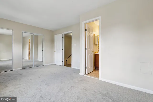 an empty room with closet and a bathroom