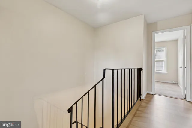 a view of a hallway with wooden floor and entryway
