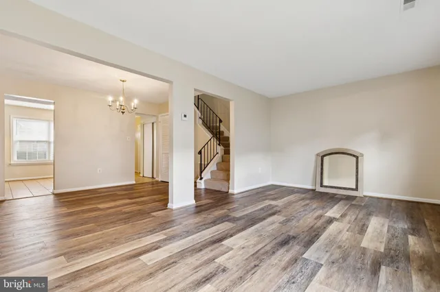 a view of empty room with wooden floor and stairs