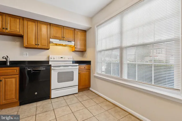 a kitchen with a stove a sink and a window