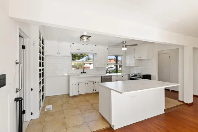 a large white kitchen with cabinets