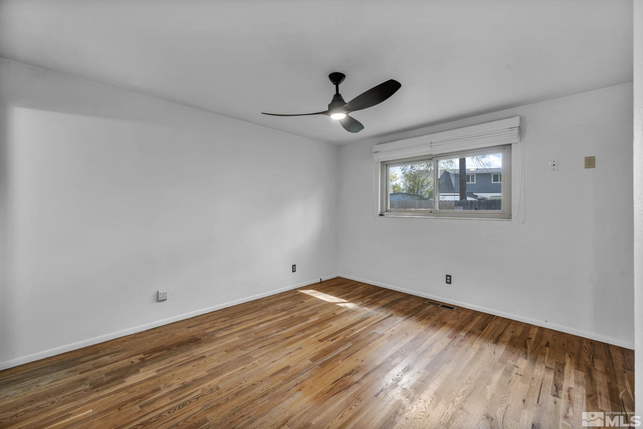 909 Norrie Drive Carson City, NV 89703 - Photo 19 of 39 a view of empty room with wooden floor and fan