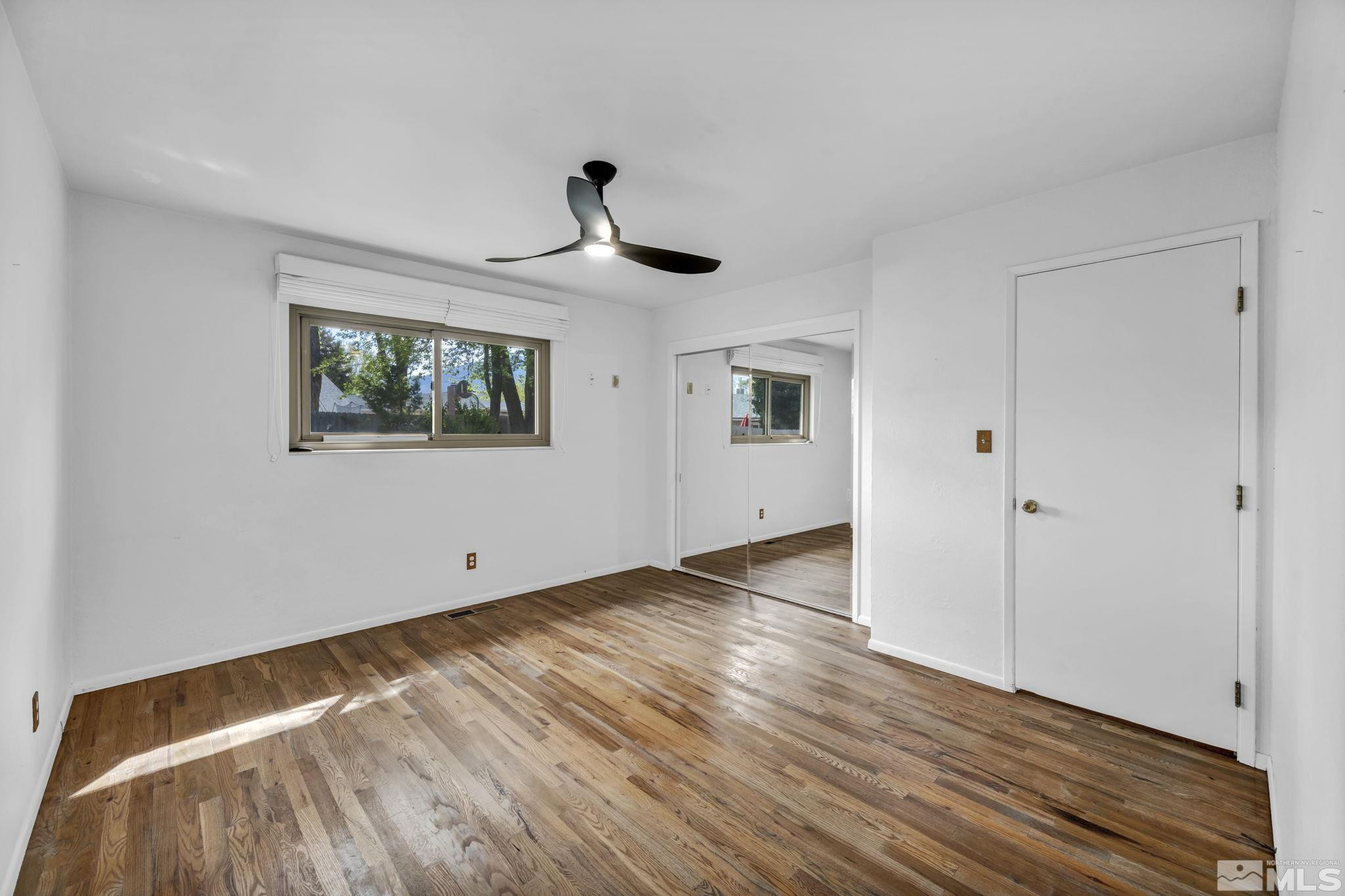 909 Norrie Drive Carson City, NV 89703 - Photo 21 of 39 a view of empty room with wooden floor and fan
