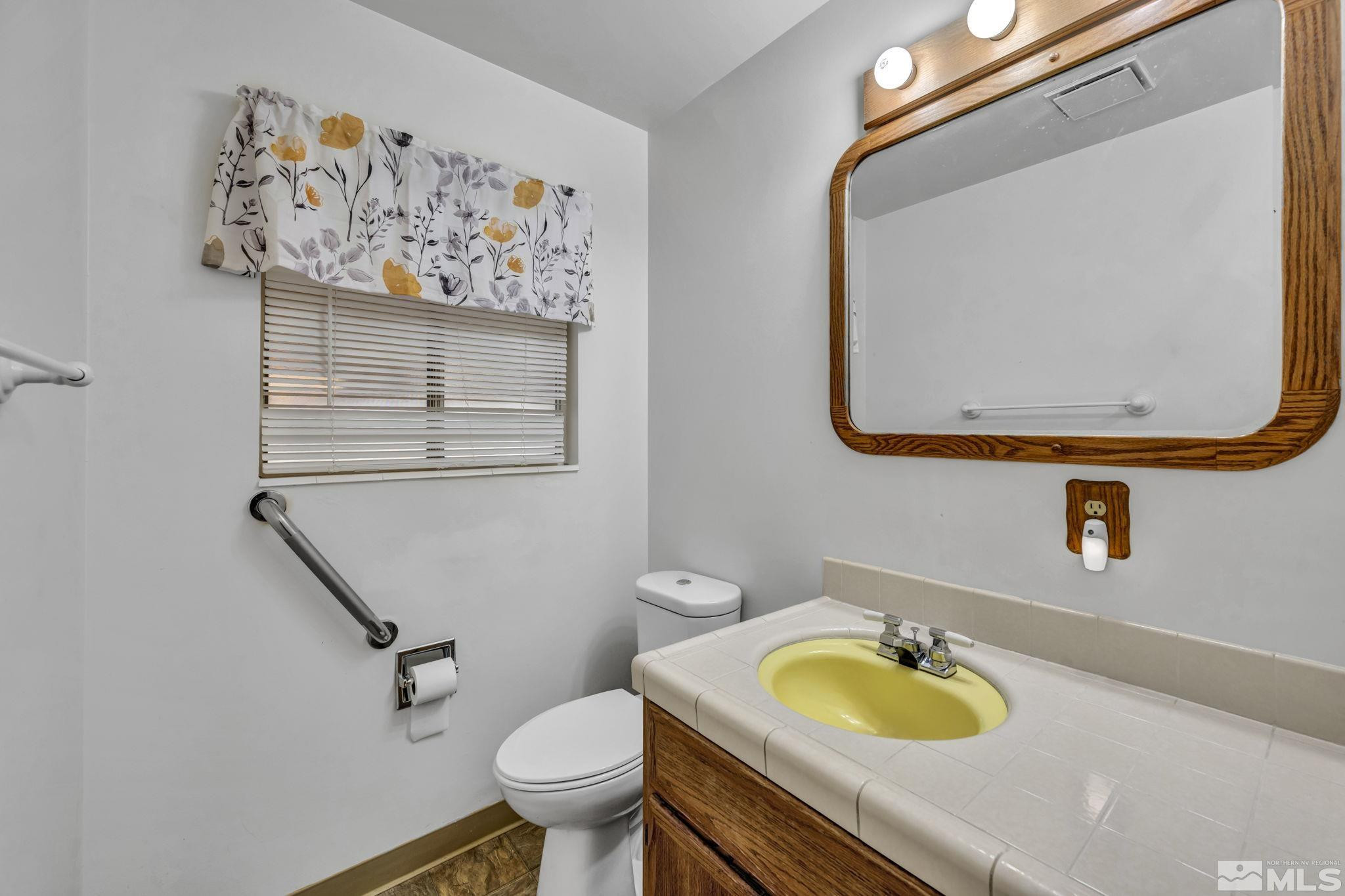 909 Norrie Drive Carson City, NV 89703 - Photo 25 of 39 a bathroom with a toilet sink and mirror