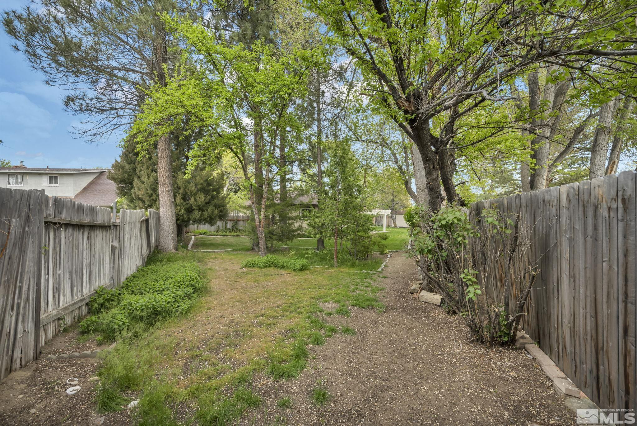 909 Norrie Drive Carson City, NV 89703 - Photo 34 of 39 a view of a yard with large trees and wooden fence