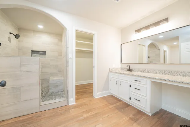 a bathroom with a granite countertop sink mirror and shower