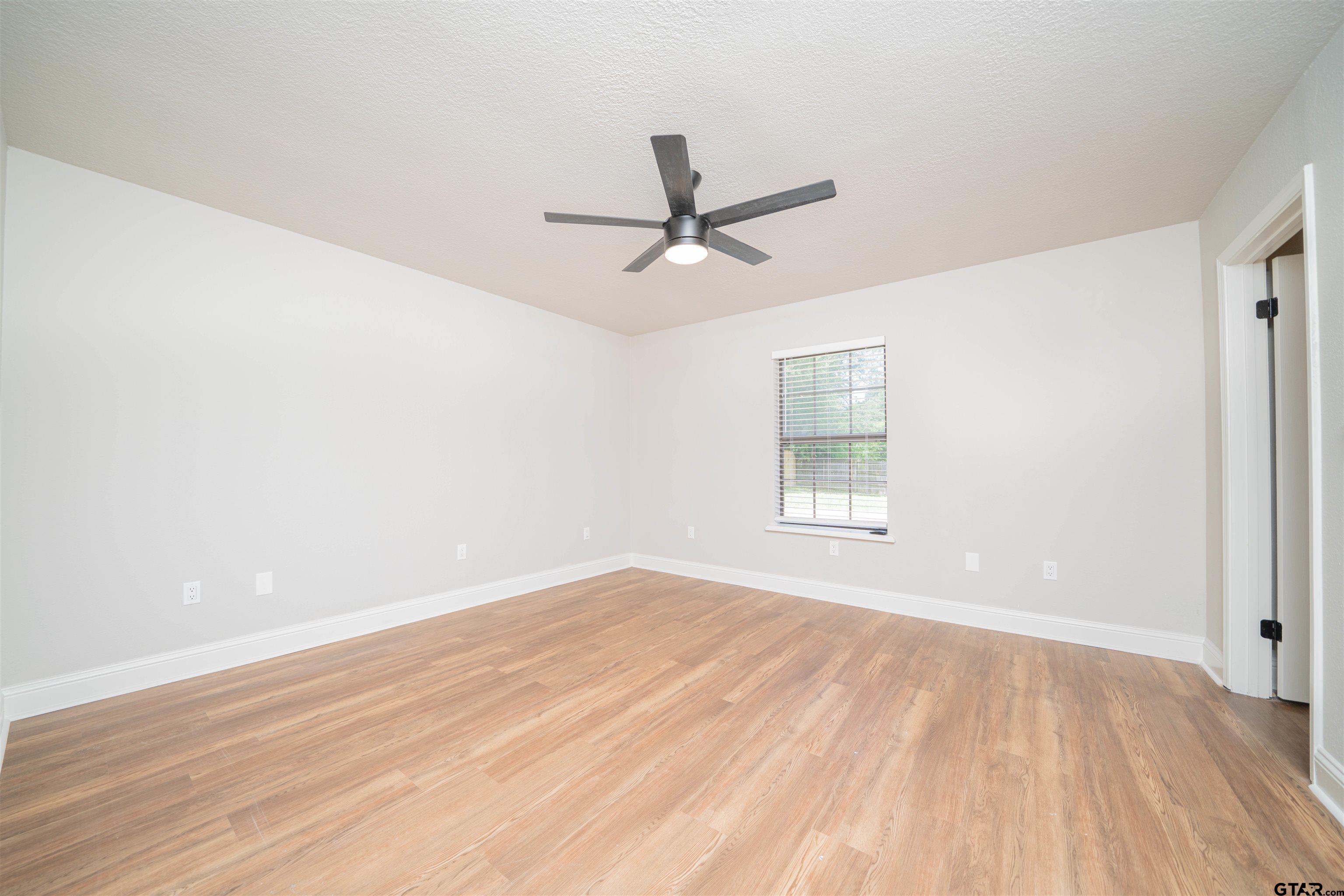 291 Taylor George Road Longview, TX 75605 - Photo 16 of 35 a view of empty room with wooden floor and fan