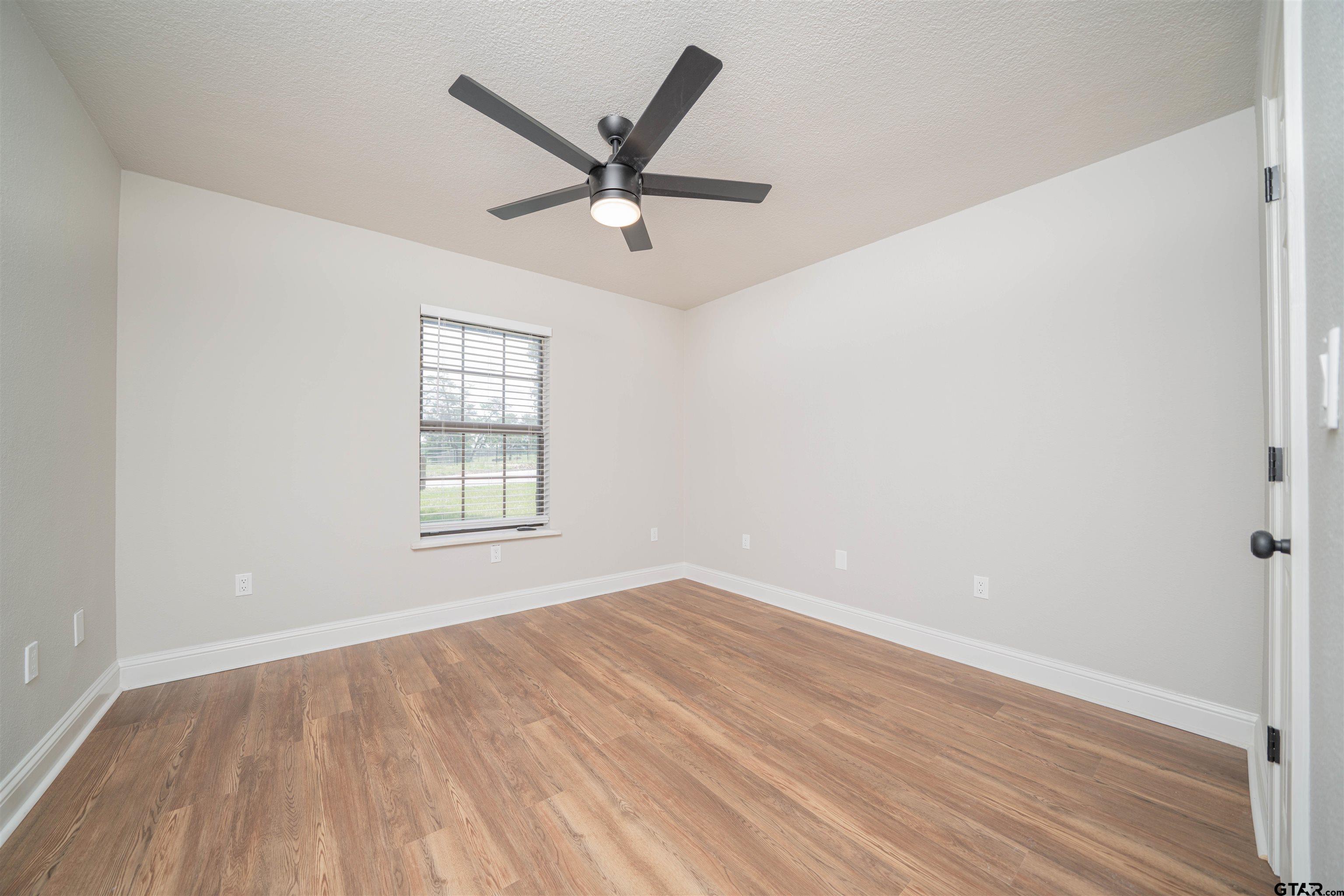 291 Taylor George Road Longview, TX 75605 - Photo 17 of 35 an empty room with wooden floor fan and windows