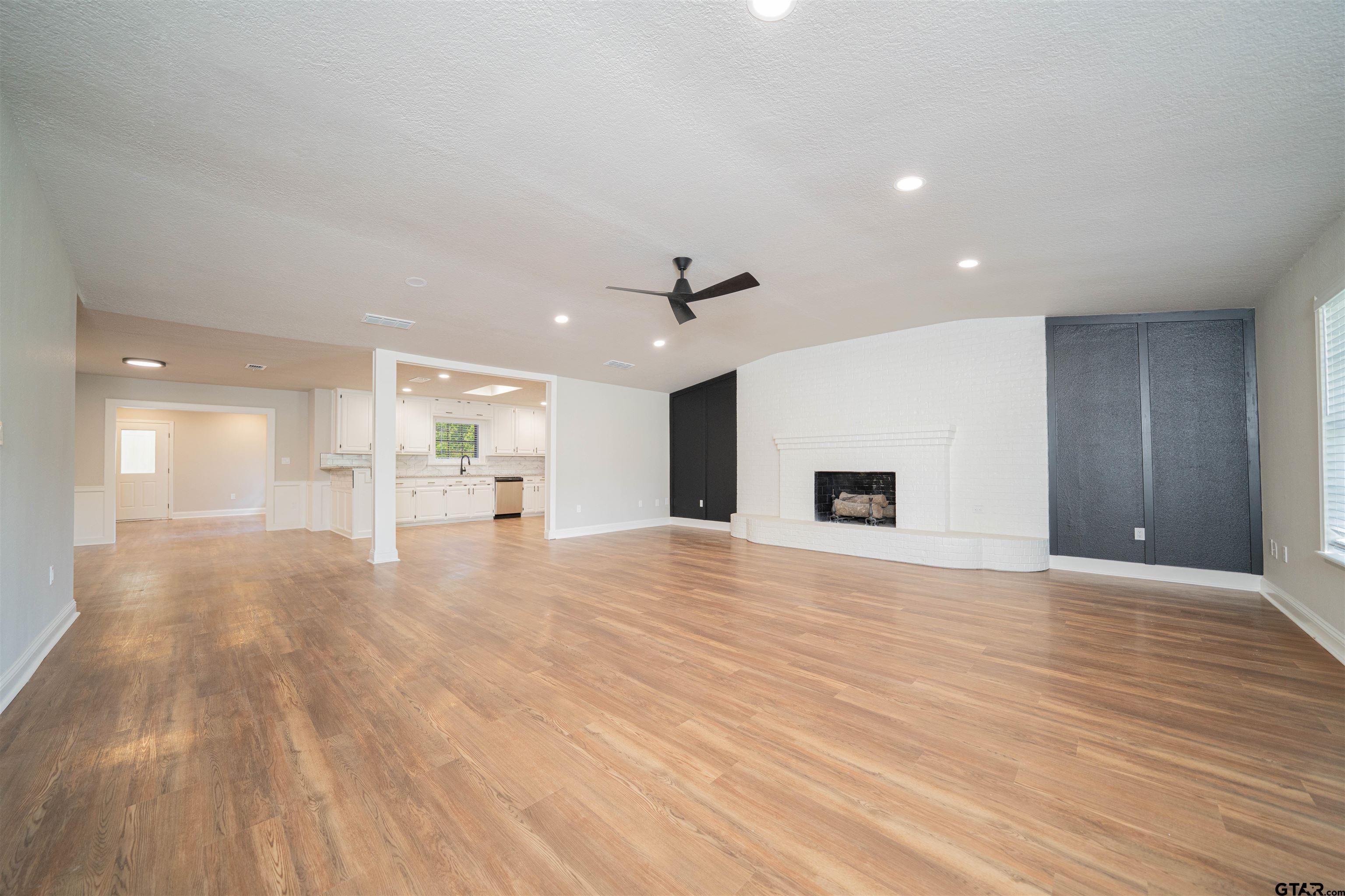 291 Taylor George Road Longview, TX 75605 - Photo 2 of 35 a view of an empty room with wooden floor and a kitchen