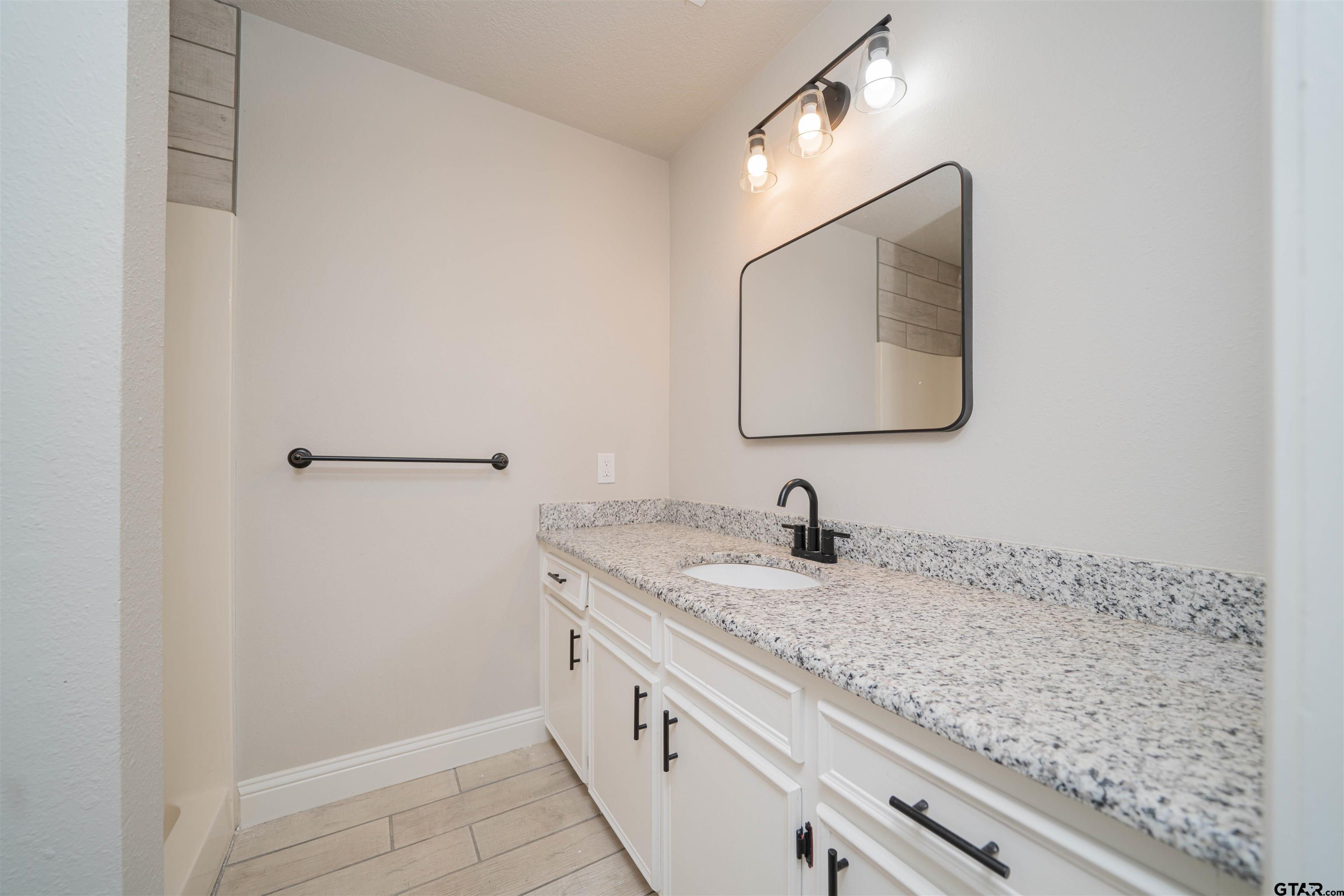 291 Taylor George Road Longview, TX 75605 - Photo 22 of 35 a bathroom with a granite countertop sink and mirror