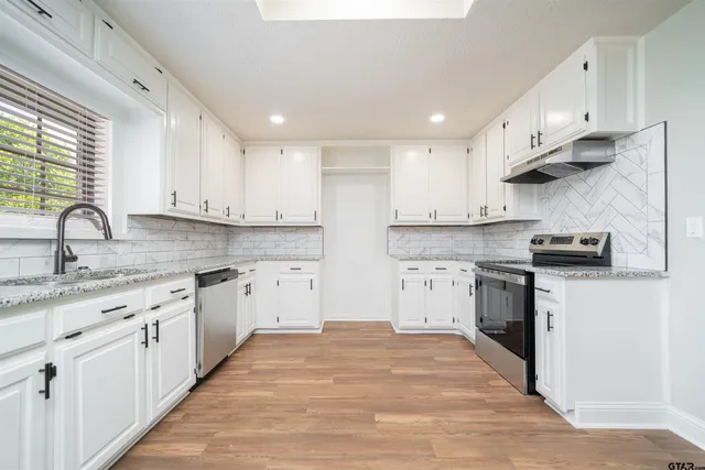a kitchen with stainless steel appliances granite countertop a sink and cabinets