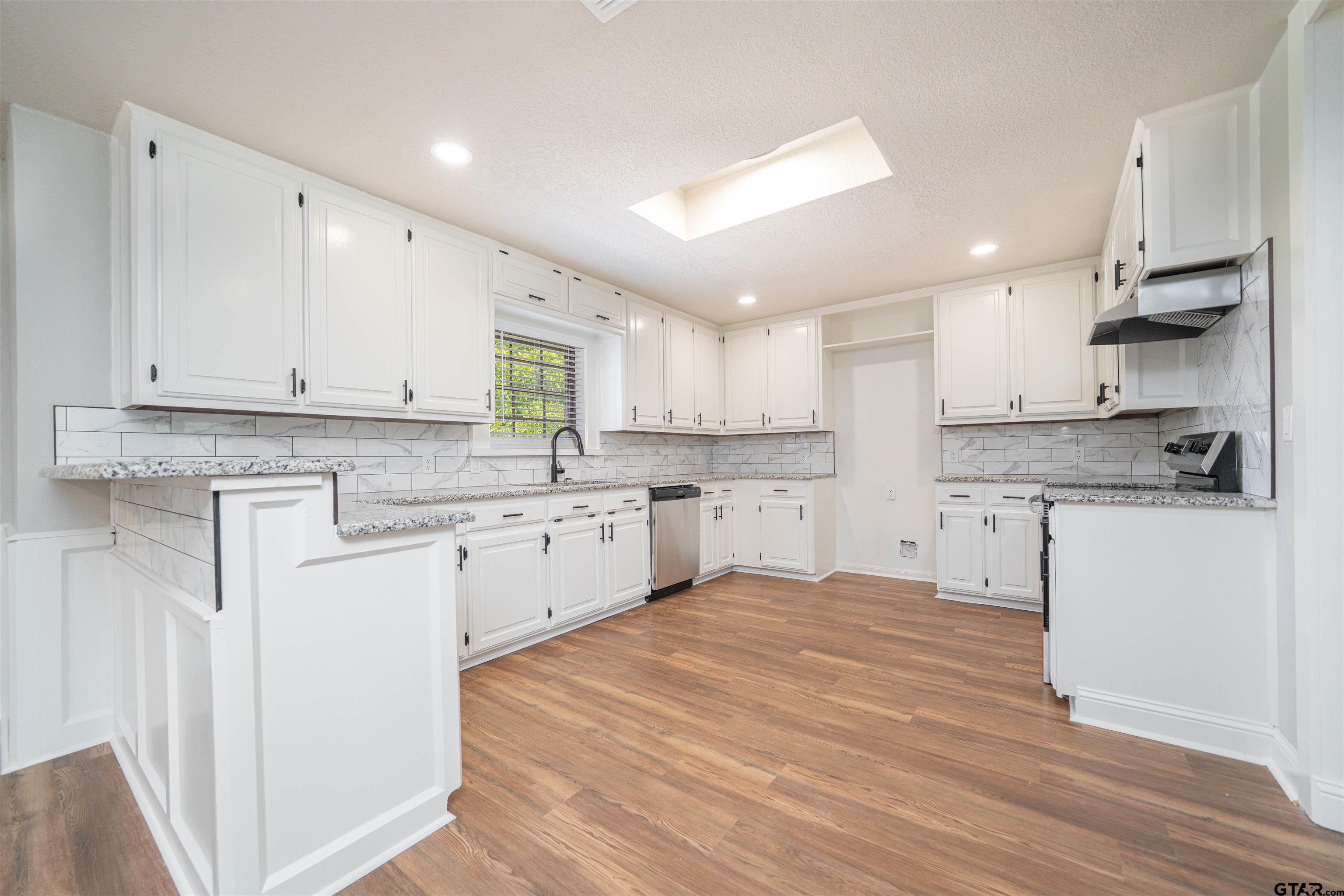 291 Taylor George Road Longview, TX 75605 - Photo 9 of 35 a kitchen with stainless steel appliances granite countertop a stove a sink and white cabinets