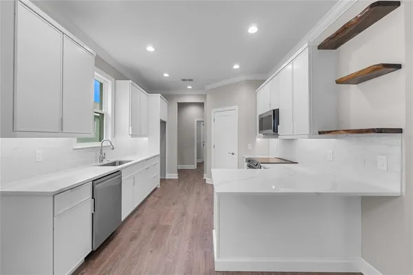 a kitchen with a stove a sink and a microwave