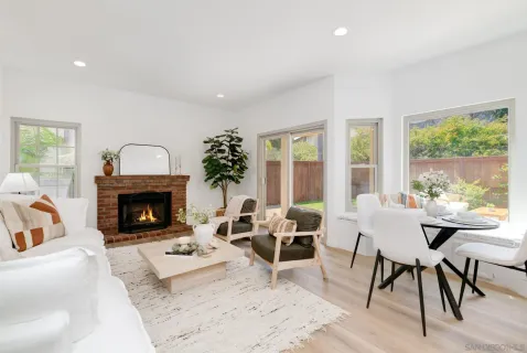 a living room with furniture a fireplace and a large window