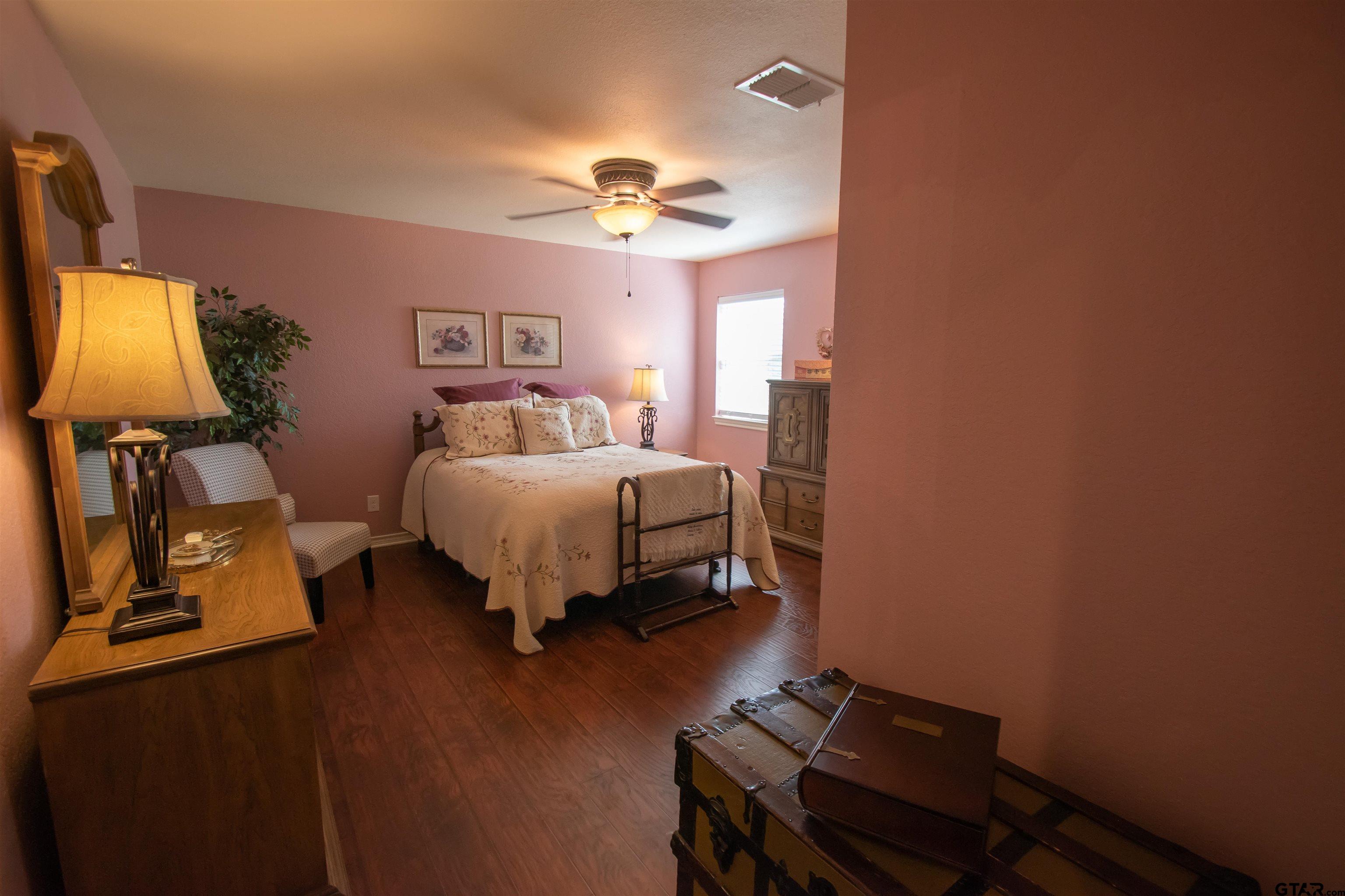 23120 Saddle Ridge Court Lindale, TX 75771 - Photo 21 of 34 a bedroom with a bed and a chandelier