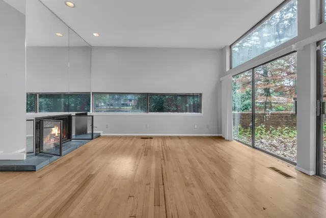 an empty room with wooden floor and a fireplace