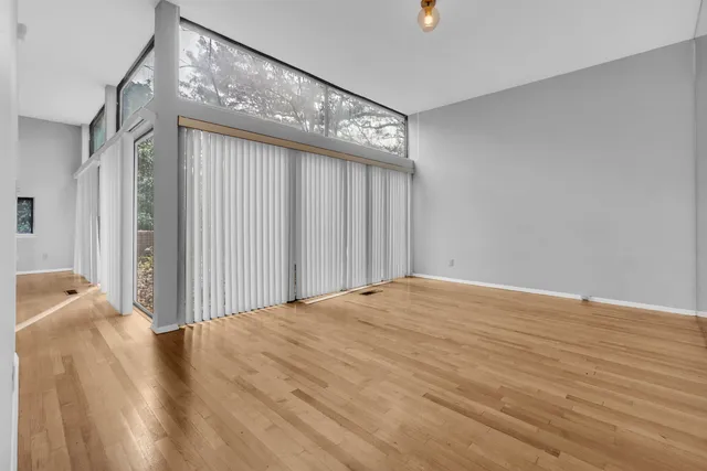 a view of a bedroom with wooden floor and windows