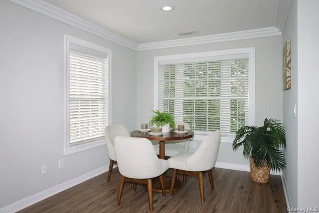 a dining room with furniture potted plants and wooden floor