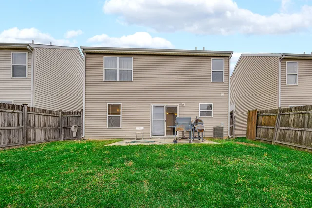 a front view of house with backyard and green space