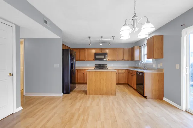 a kitchen with stainless steel appliances granite countertop a sink a stove and refrigerator