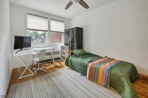 a bedroom with a bed and a flat tv screen on dresser