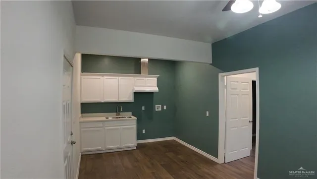 an empty room with a ceiling fan and window