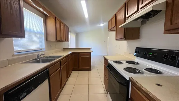 a kitchen with a sink a stove top oven and cabinets