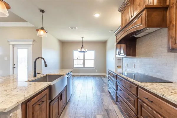 a kitchen with granite countertop stainless steel appliances a sink window and wooden floor