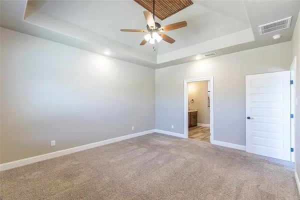 an empty room with closet and a ceiling fan