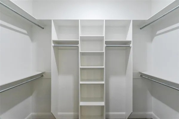 a view of walk in closet with empty racks