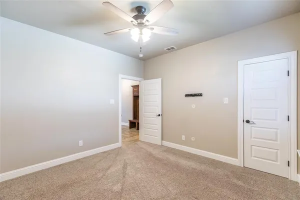 an empty room with closet and a ceiling fan