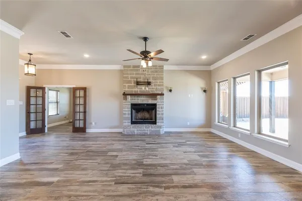 a view of an empty room with a fireplace and a window