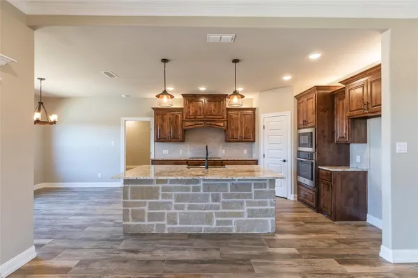 a kitchen with kitchen island a counter top space a sink cabinets and stainless steel appliances
