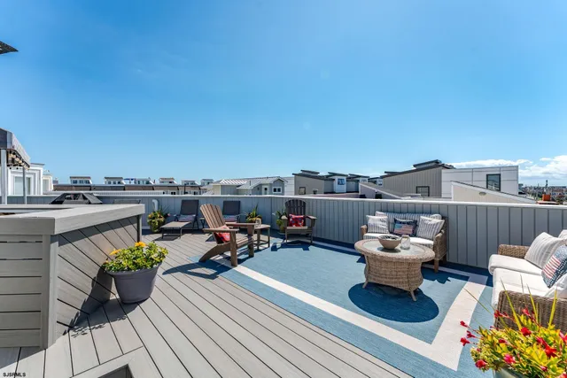 an aerial view of a house with roof deck and furniture