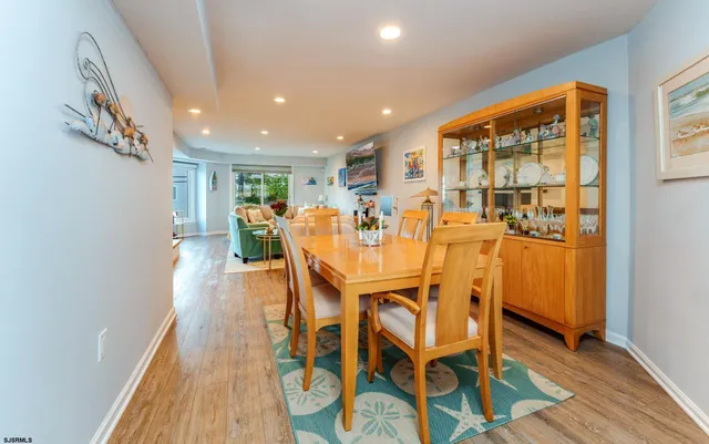 a kitchen with stainless steel appliances granite countertop a stove a sink a refrigerator a dining table and chairs