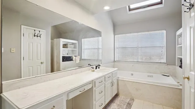 a bathroom with a tub sink and mirror