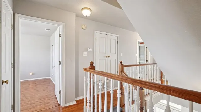 a view of a hallway with wooden floor and entryway