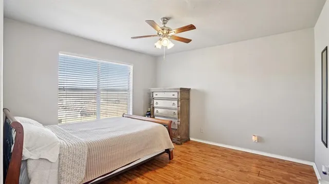 a bedroom with a bed and a ceiling fan