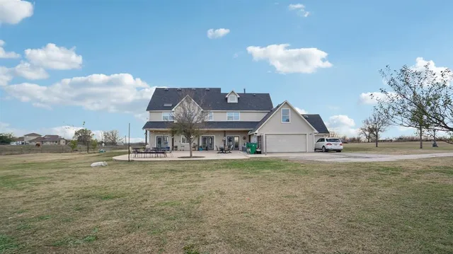 a view of a house with backyard and trees