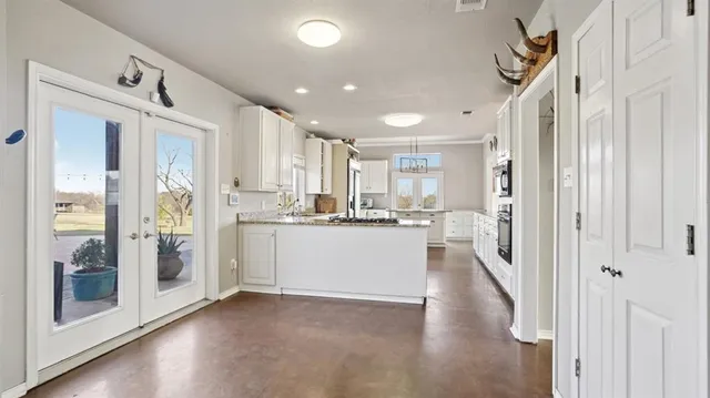 a view of a kitchen with a refrigerator and wooden floor