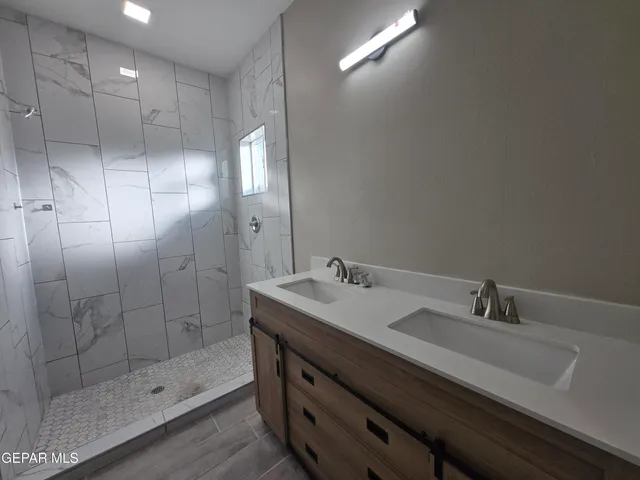 a bathroom with a shower sink and mirror