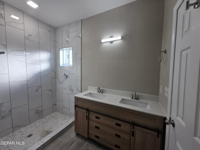 a bathroom with a shower sink and mirror