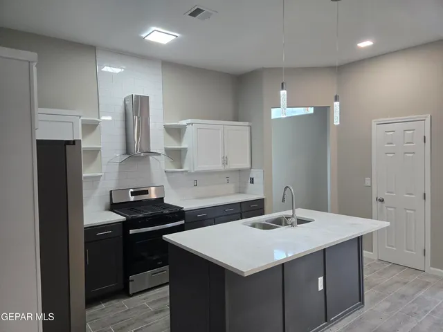a kitchen with a sink a stove a refrigerator and cabinets