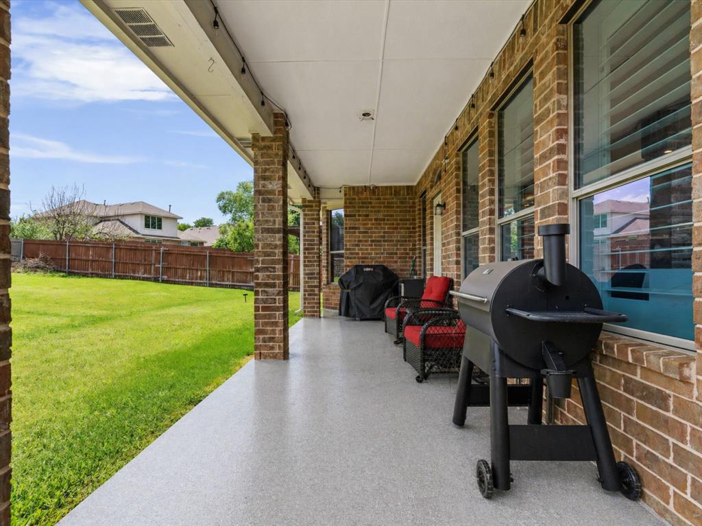 8156 Rock Elm Road Fort Worth, TX 76131 - Photo 39 of 40 Covered back patio with brick columns and a speckled concrete floor