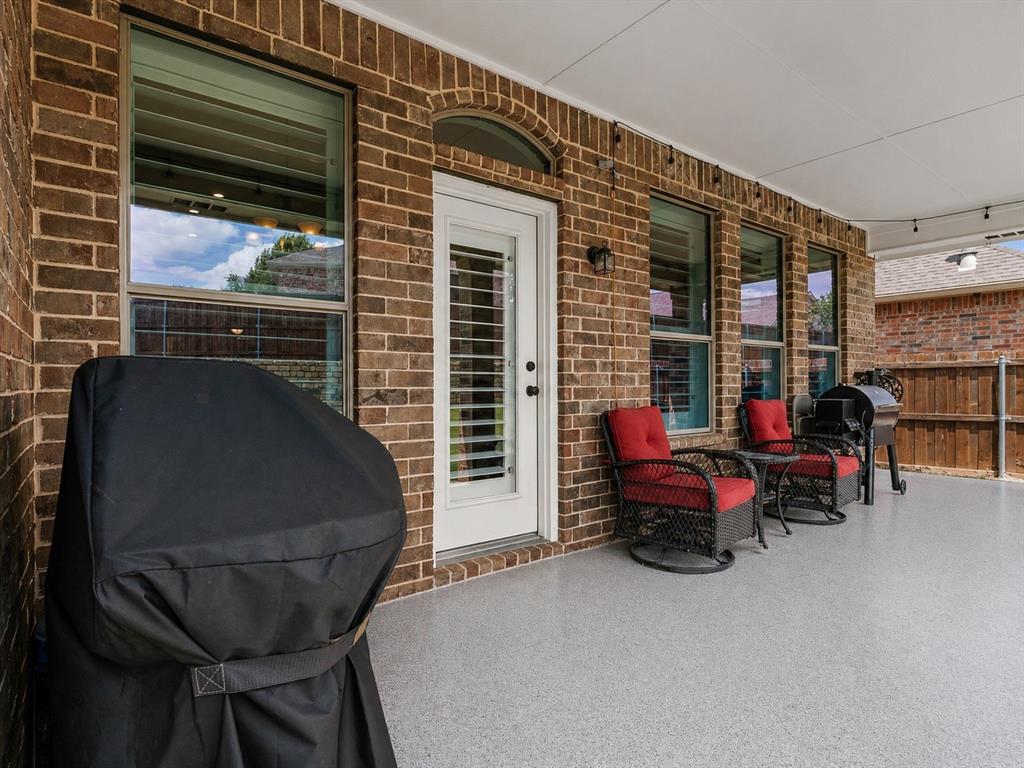 8156 Rock Elm Road Fort Worth, TX 76131 - Photo 40 of 40 Covered patio featuring brick exterior, a white door with integrated blinds, and multiple windows