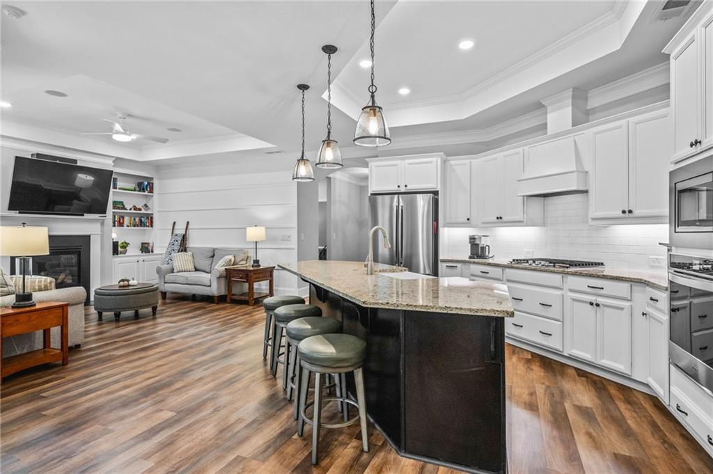 4883 Pleasantry Way Northwest Acworth, GA 30101 - Photo 12 of 46 a kitchen with stainless steel appliances kitchen island granite countertop a table chairs sink and cabinets