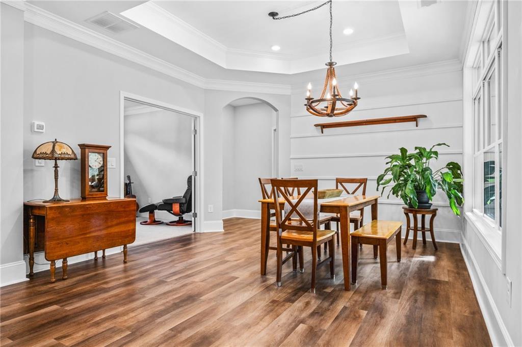 4883 Pleasantry Way Northwest Acworth, GA 30101 - Photo 16 of 46 a dining room with chandelier fan and wooden floor